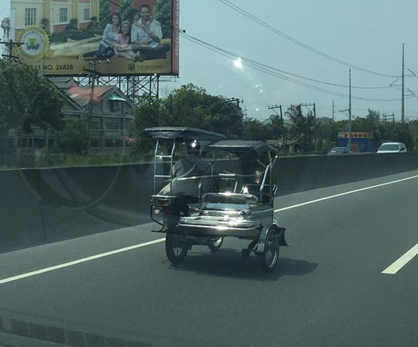 A Tricycle Driving Through NLEX